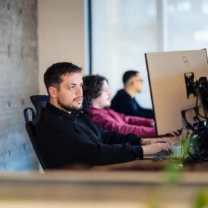 Team members using laptops in a workspace